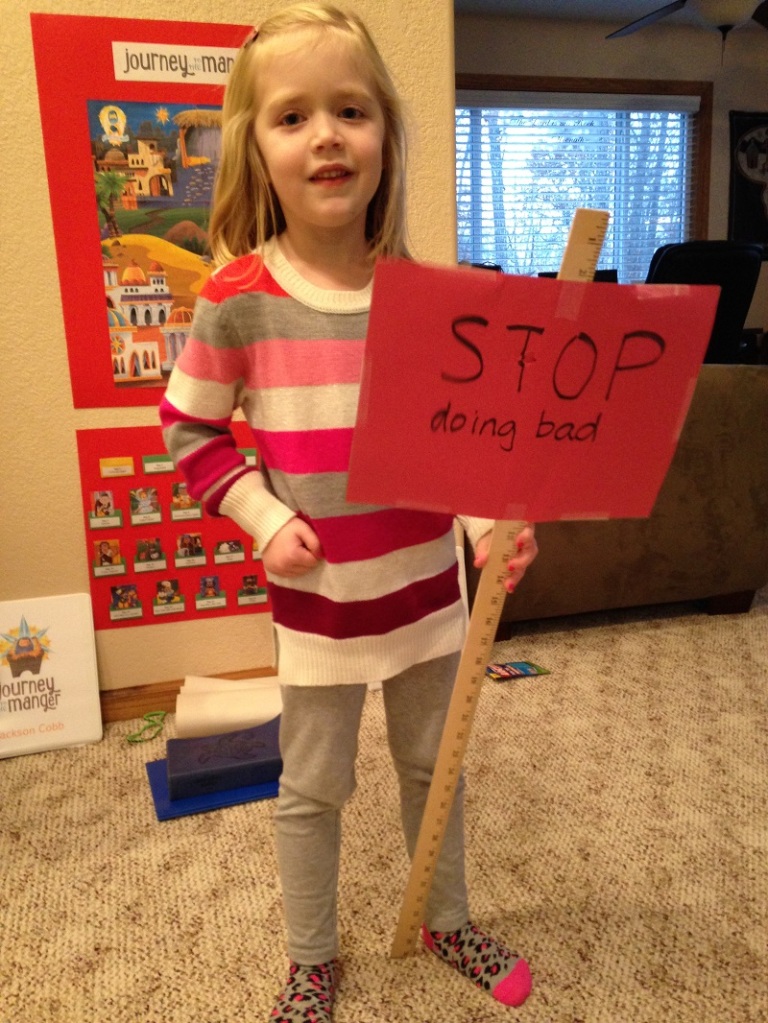 Lauren hold up the Red Light sign that holds the prophet Micah's message to the people of his day: Stop doing bad things!